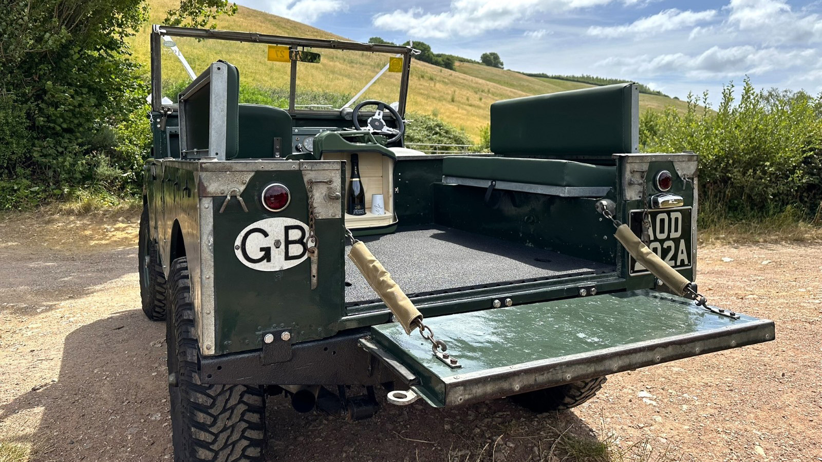 rear seating area inside Land Rover Series 1. Two Green bench seat facing each others