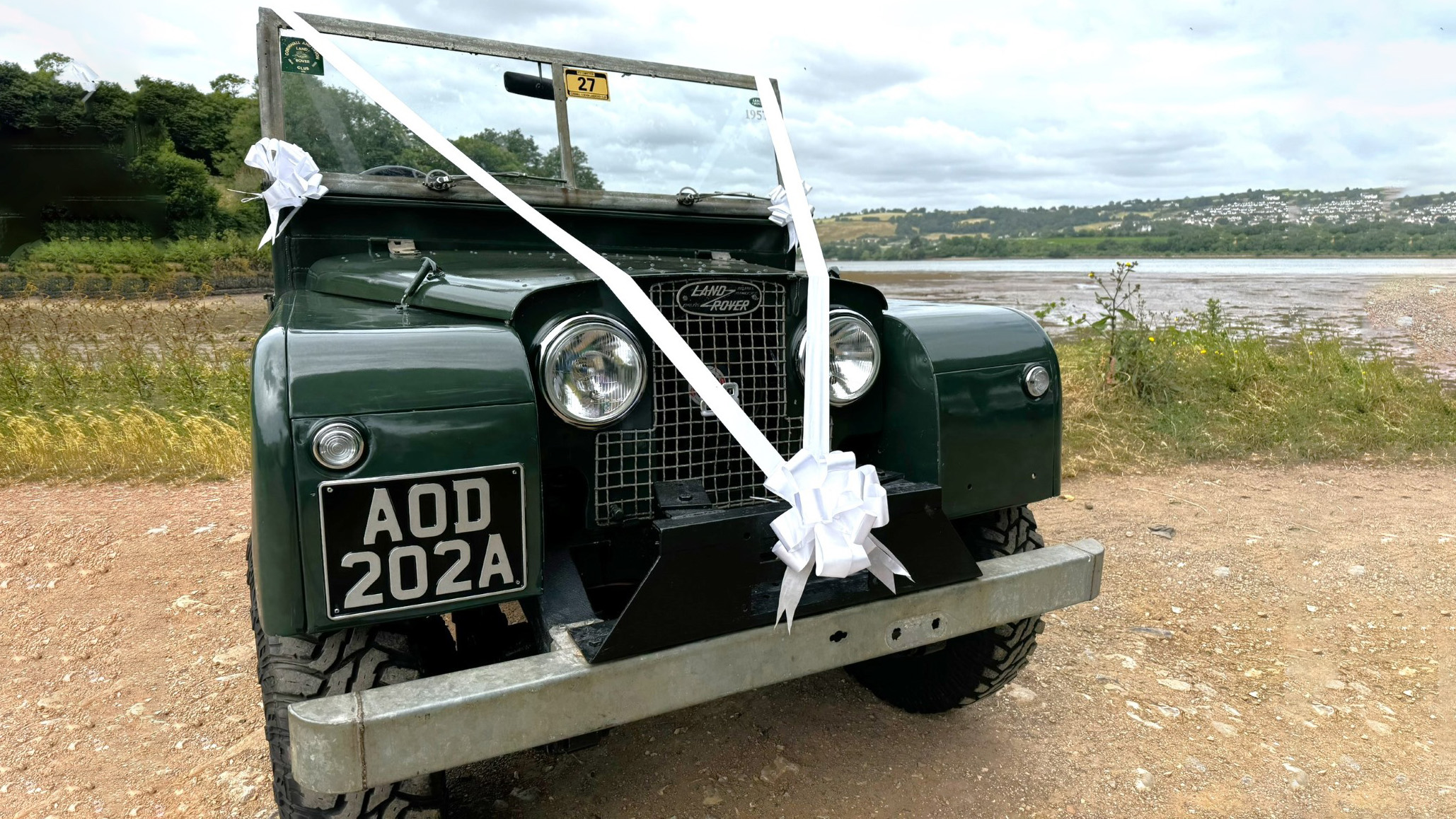 Front view of Green Land rover decorated with white Ribbons and a large White Bow at the front