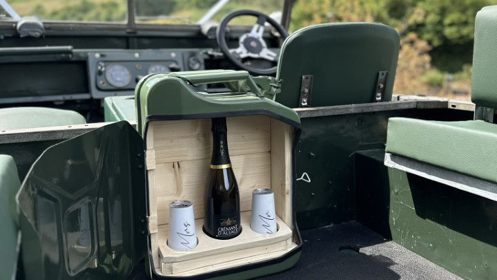 custom-made- ottle holder made of an old green petrol can. A bottle and 2 glasses in side the holder