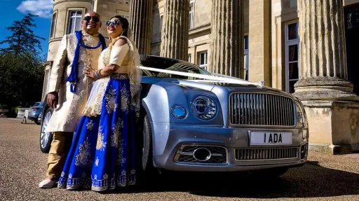 Asian couple in their traditional outfit smiling in front of a Silver Benltey Mulsanne at a wedding in Bradford