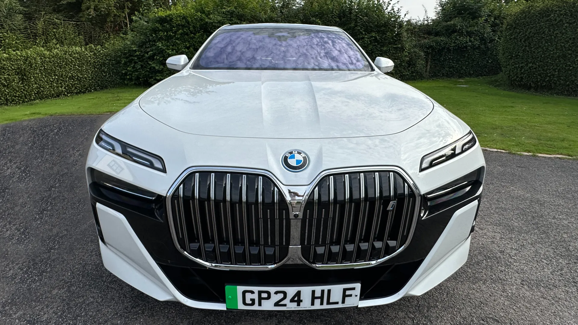 Full front view of White BMW i7 showing a large imposing and iconic BMW Front grill in chrome