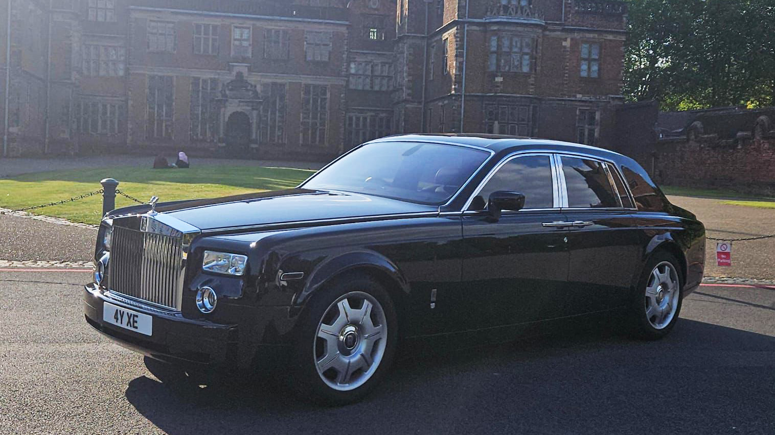 Left side view of Black Rolls-Royce Phantom parked in front of wedding venue