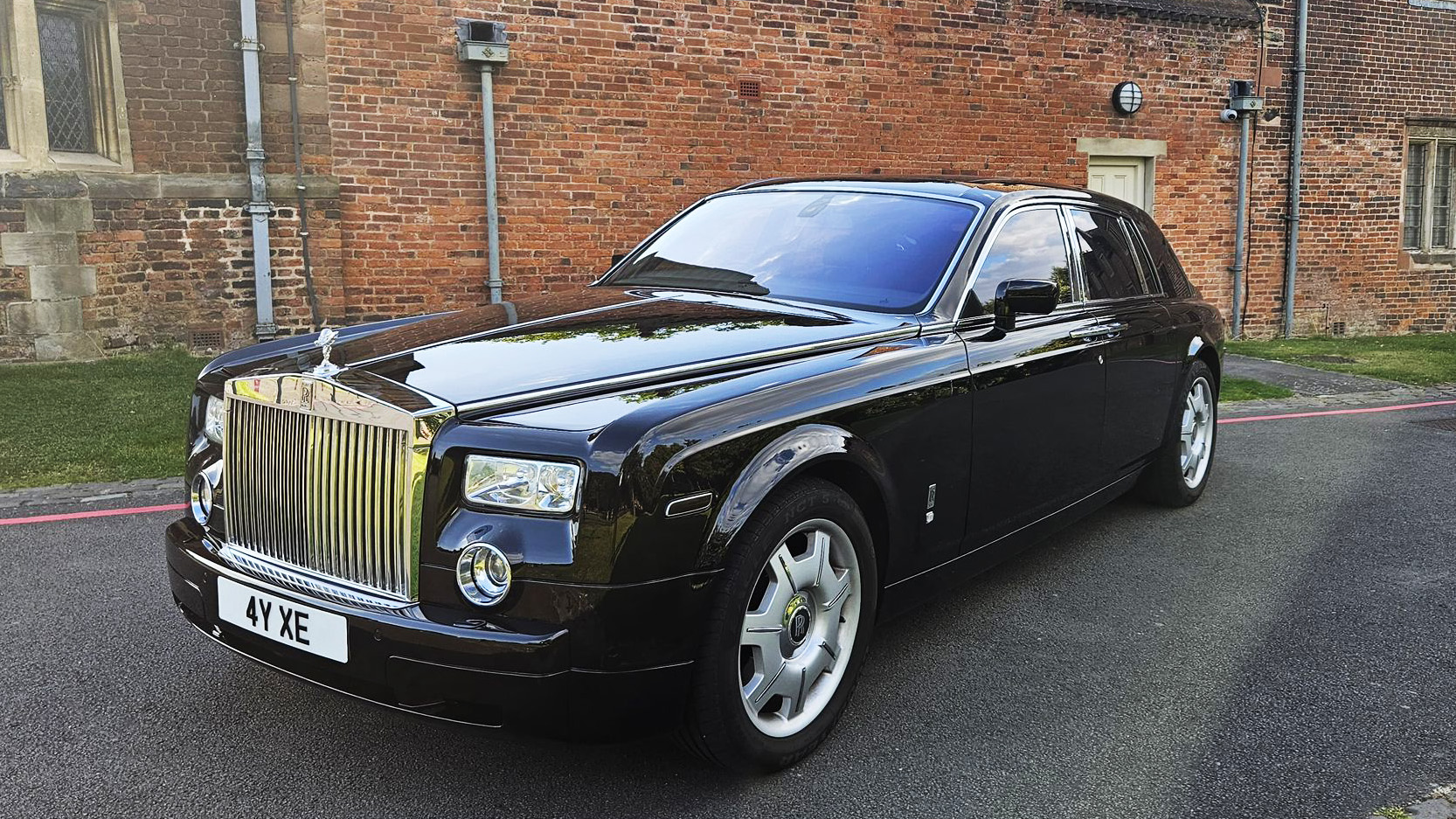 Black Rolls-Royce phantom parked in front of a wedding venue in Midlands