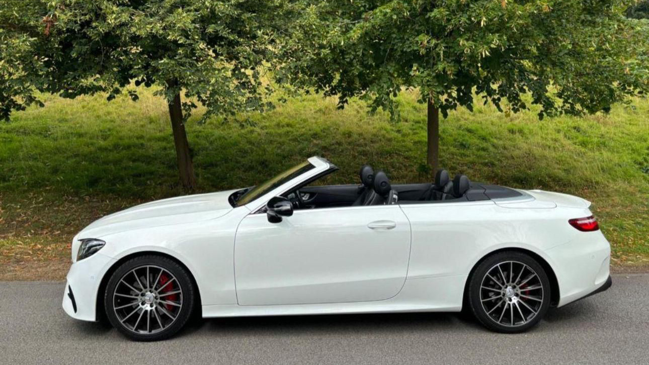 Left side view of White Mercedes Convertible with roof down