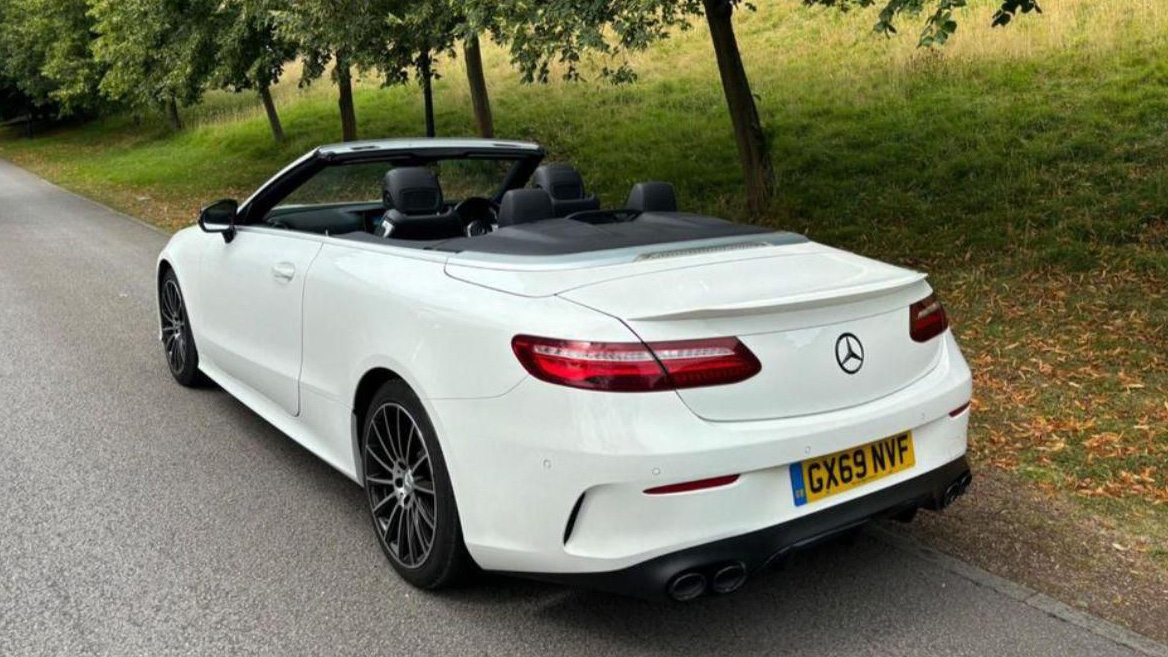 Rear view of White Mercedes E-Class convertible with roof down