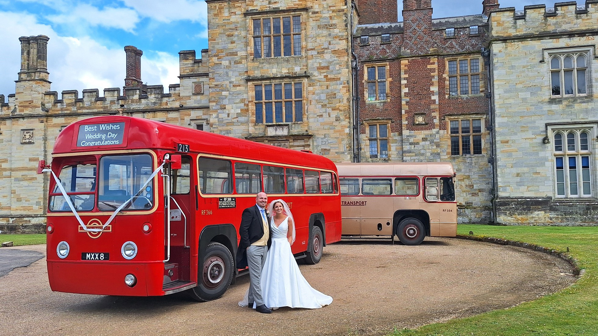 Bride and Groom standing in front of two Vintage Single Decker bus. One bus is in Red and the second one is Gold.