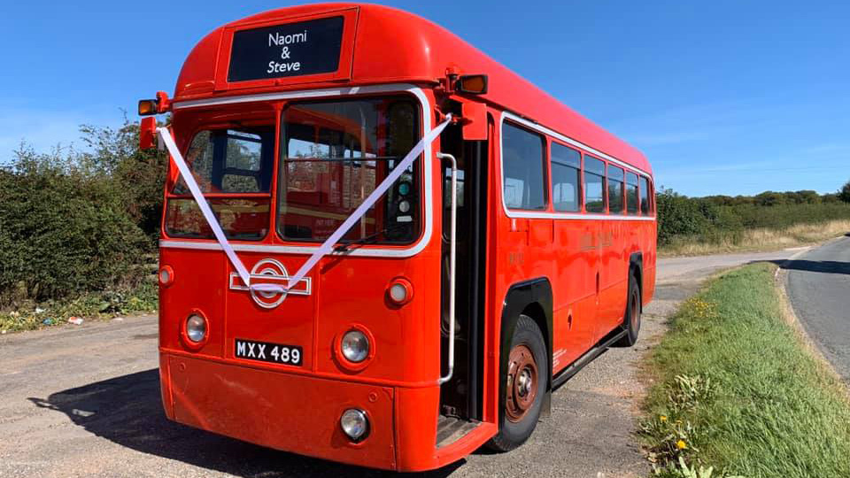 Left front side view of Classic Red bus with front door open