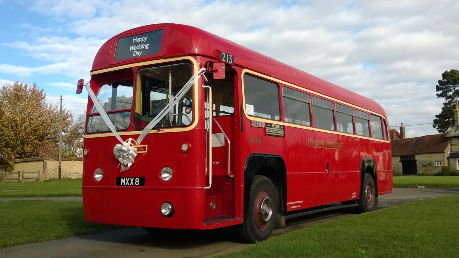 Vintage Red Single Decker Bus decorated with with ribbons parked on a path