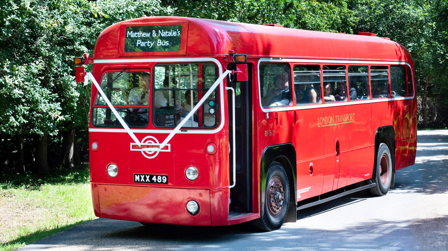 Front view of AEC Red Single Decker Bus with white ribbons