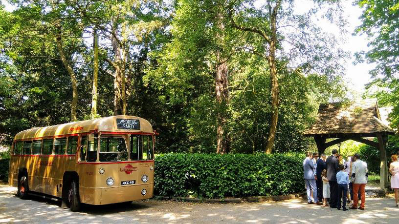 Gold Single Decker London Bus parked in front of a wedding church.