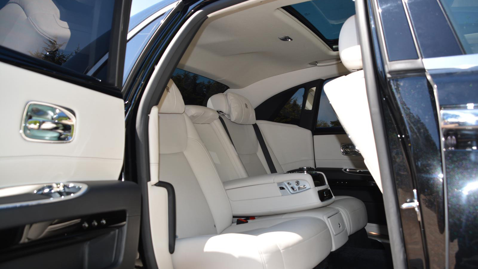 Rear passenger door open showing white leather interior seats and opened sunroof