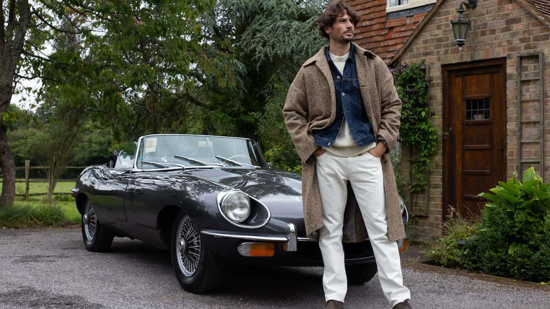 Male model standing in front of Jaguar e-type