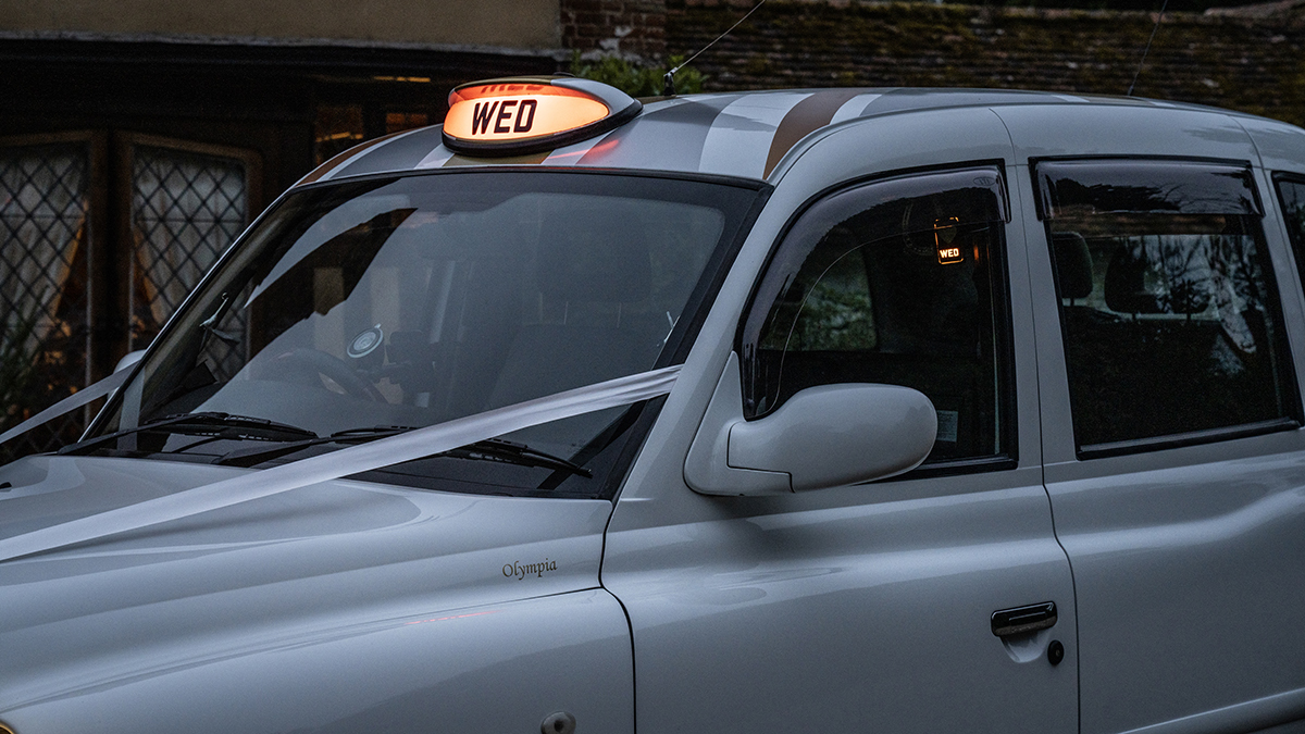 Close up view of orange taxi cab sign on top of roof with "WED" wording litup