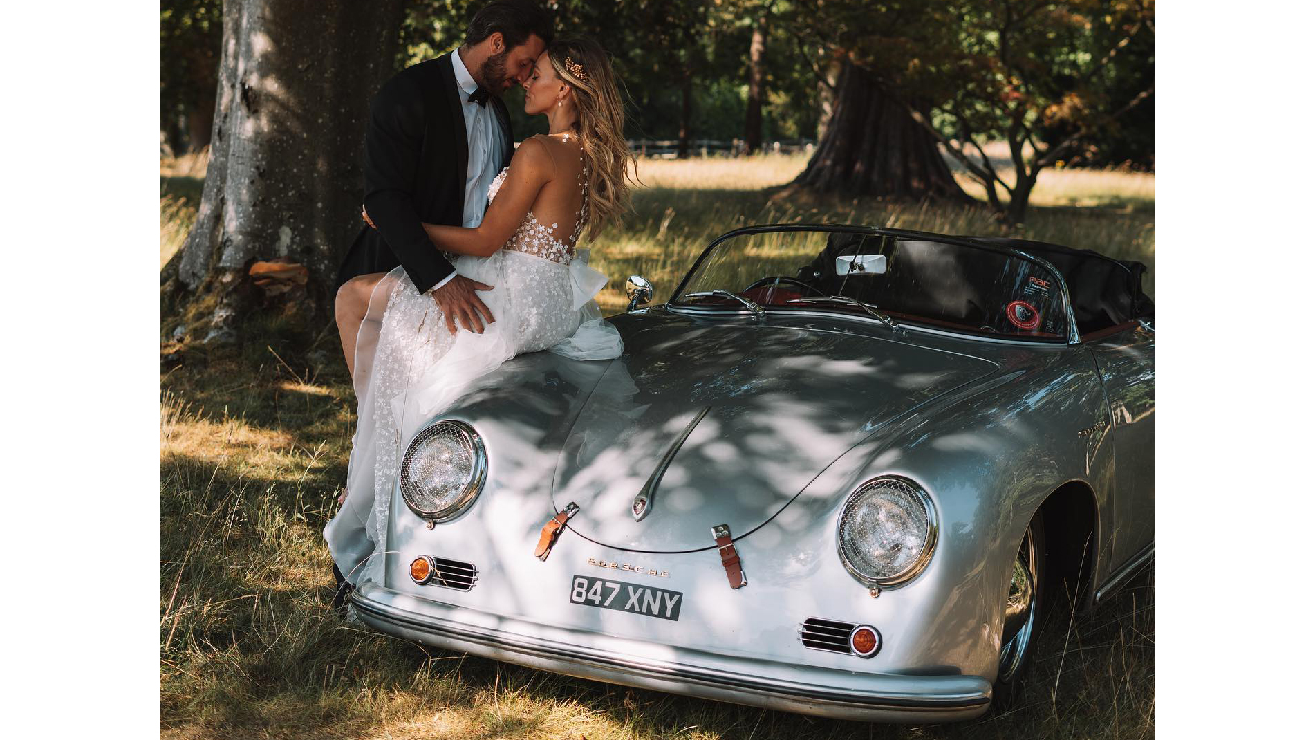 Bride and groom kissing next to Classic Porsche 356 in silver