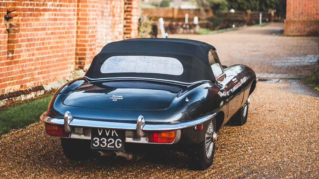 Rear view of classic Jaguar with black sot top roof closed