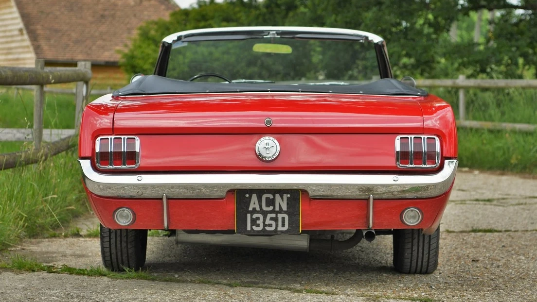 Full rear view of Red Ford Mustang with soft top down