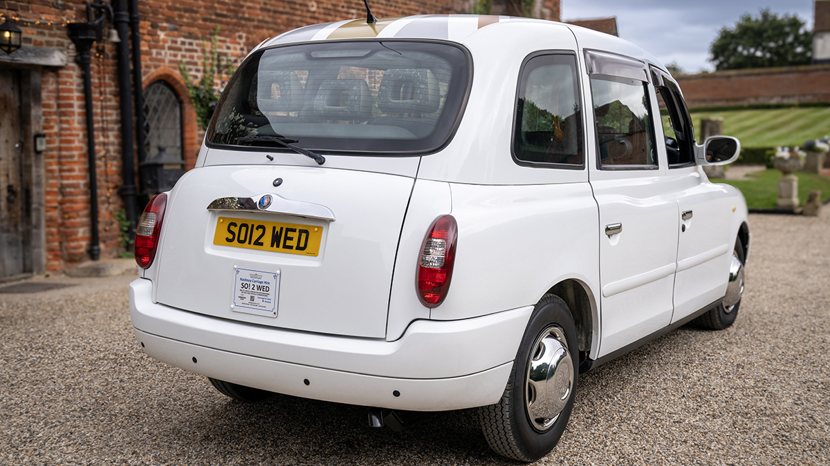 Right side rear view of white taxi cab parked in front of wedding venue in Essex