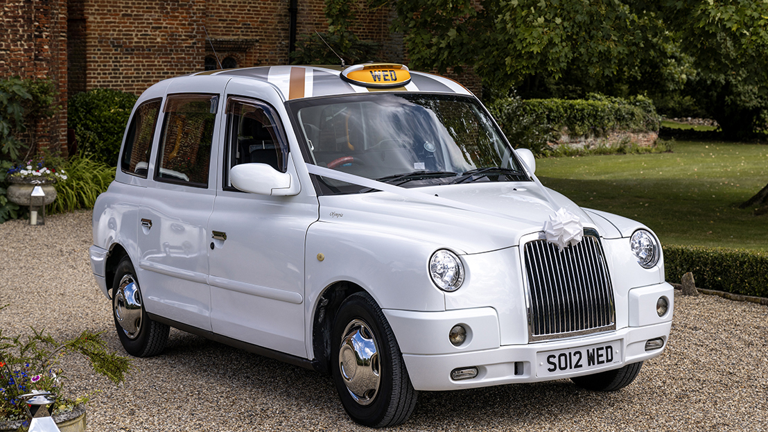 White Modern TX4 Taxi Cab with white ribbons, lit up sign on its roof and chrome wheel caps