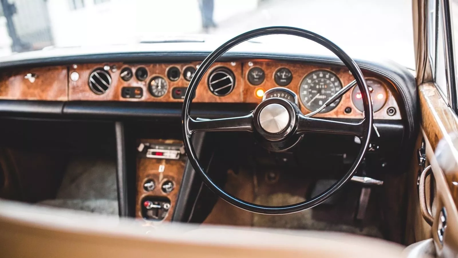 Front view of wooden dashboard and centre console inside Classic 70s Rolls-Royce