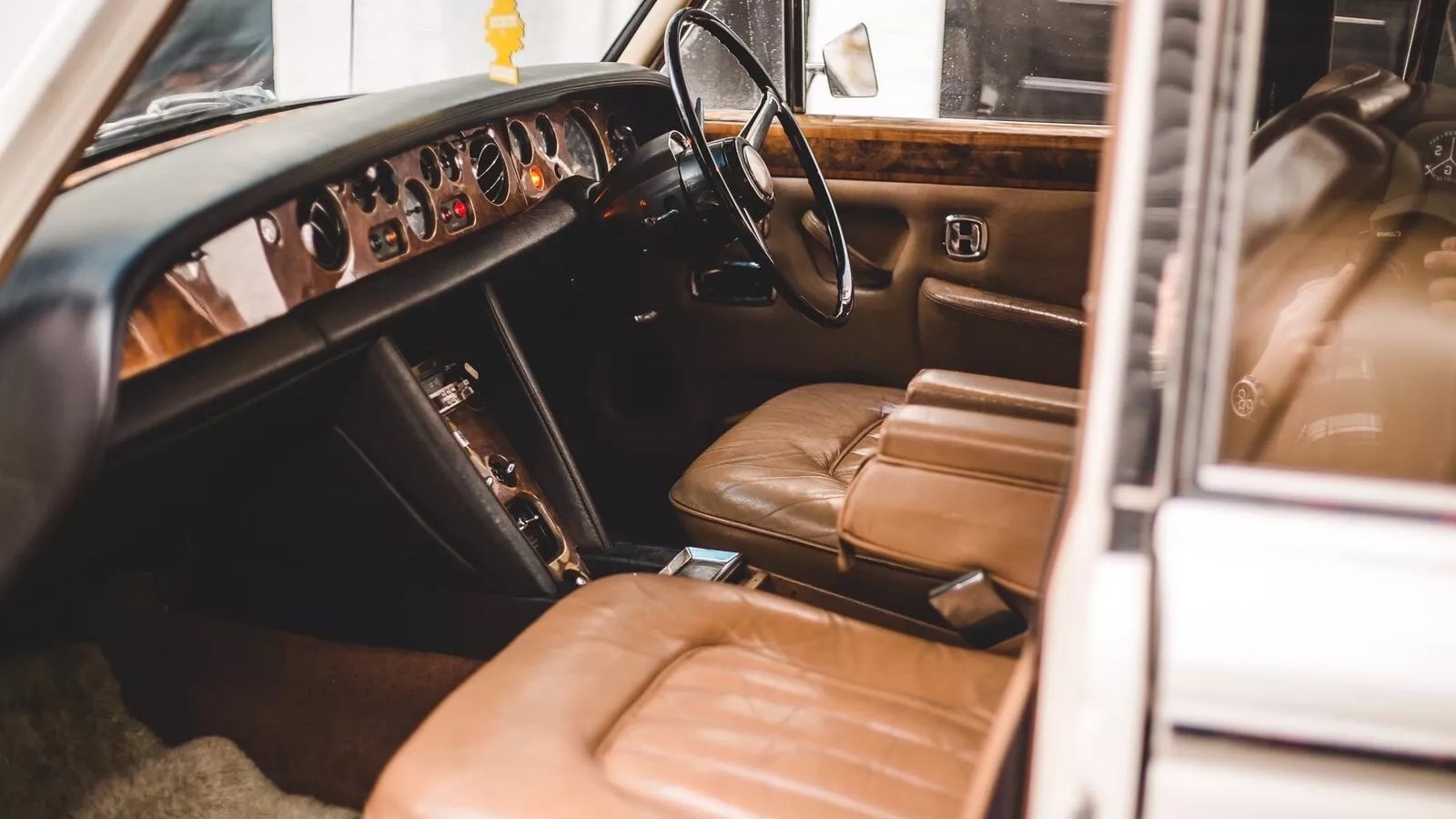 Front seating area and space in Rolls-Royce silver Shadow. Seats are cream leather interior