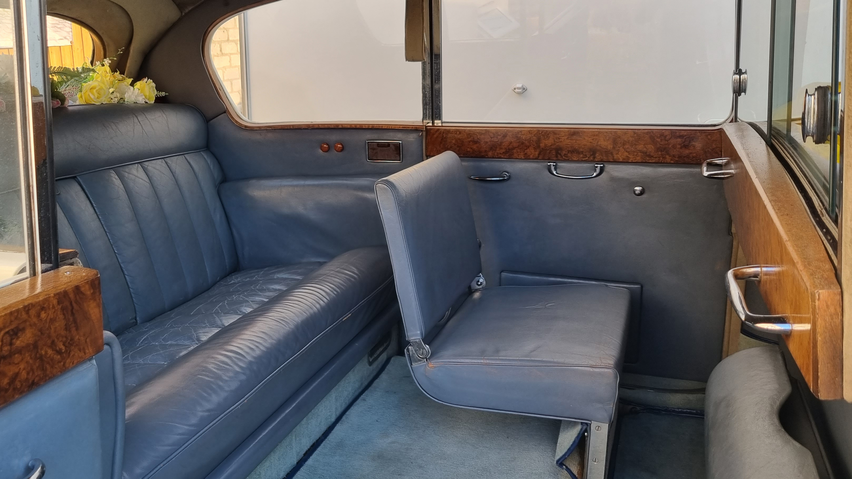 rear interior space inside Austin Princess Limousine with one of the casual seats up.