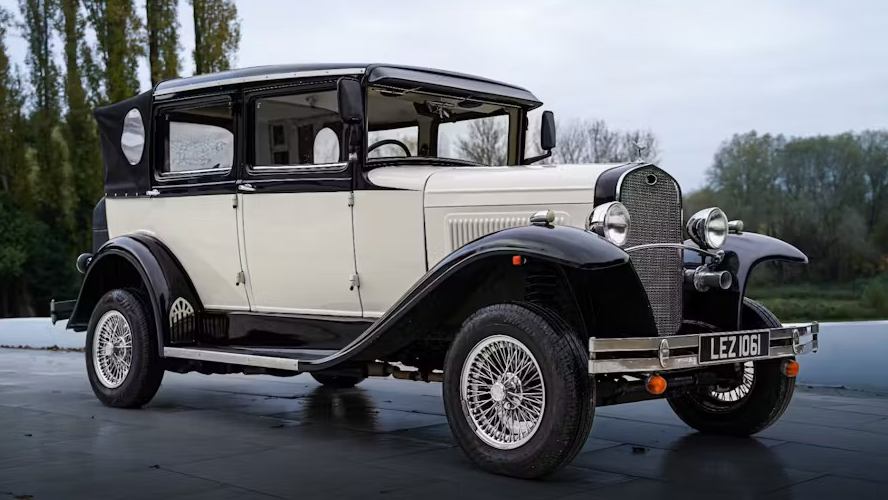 Right side view of vintage Badsworth convertible with black soft top roof and chrome spokes wheels