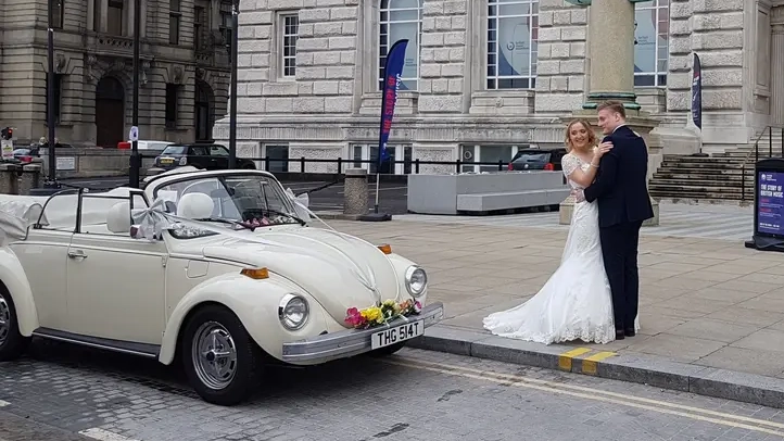 Bride and Groom standing in front of a classic vw beetle at Lancashire registry office