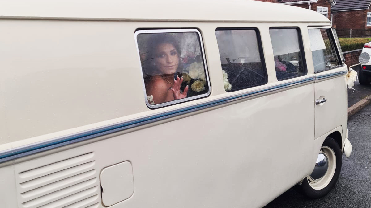 Bride inside campervan looking through one of the window