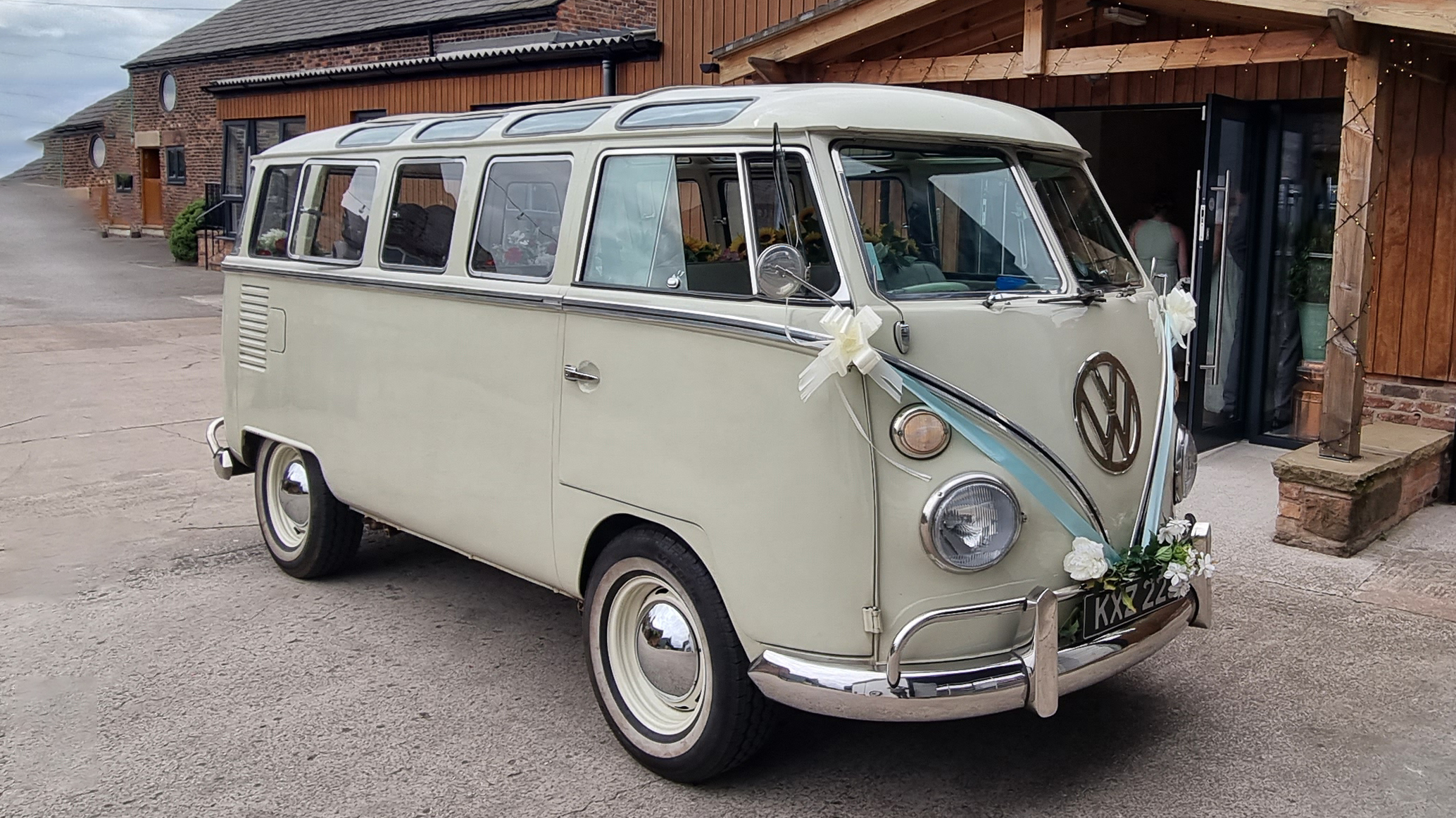 Classic VW Campervan "Samba" with blue ribbons and white bows in front of wedding venue in Southport