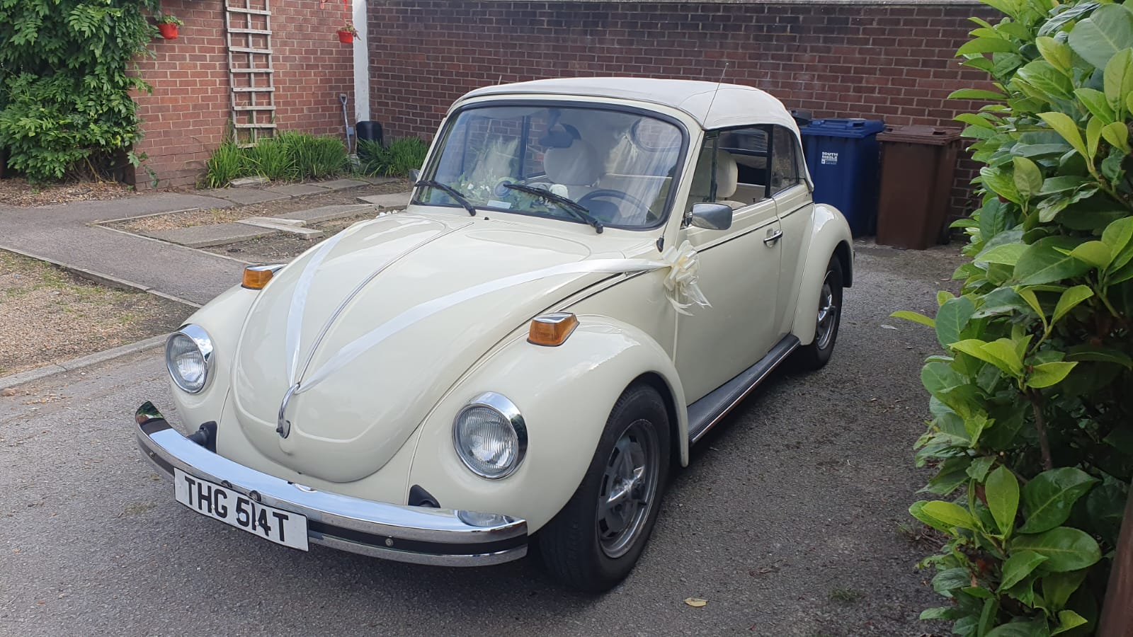 VW beetle in cream with white soft top roof closed