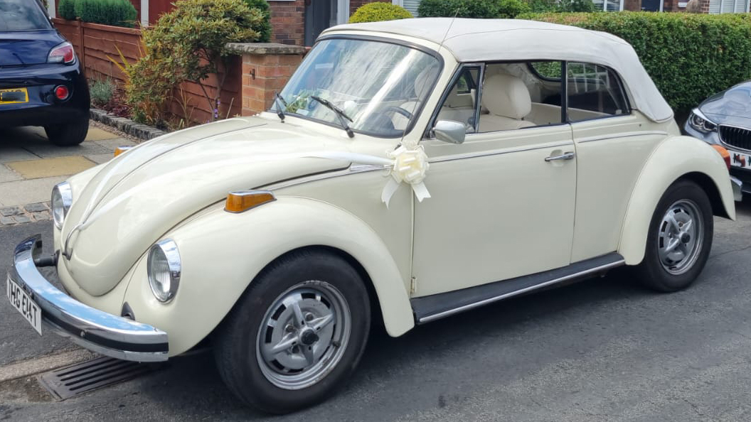 Left side view of classic vw beetle with its white soft top roof closed