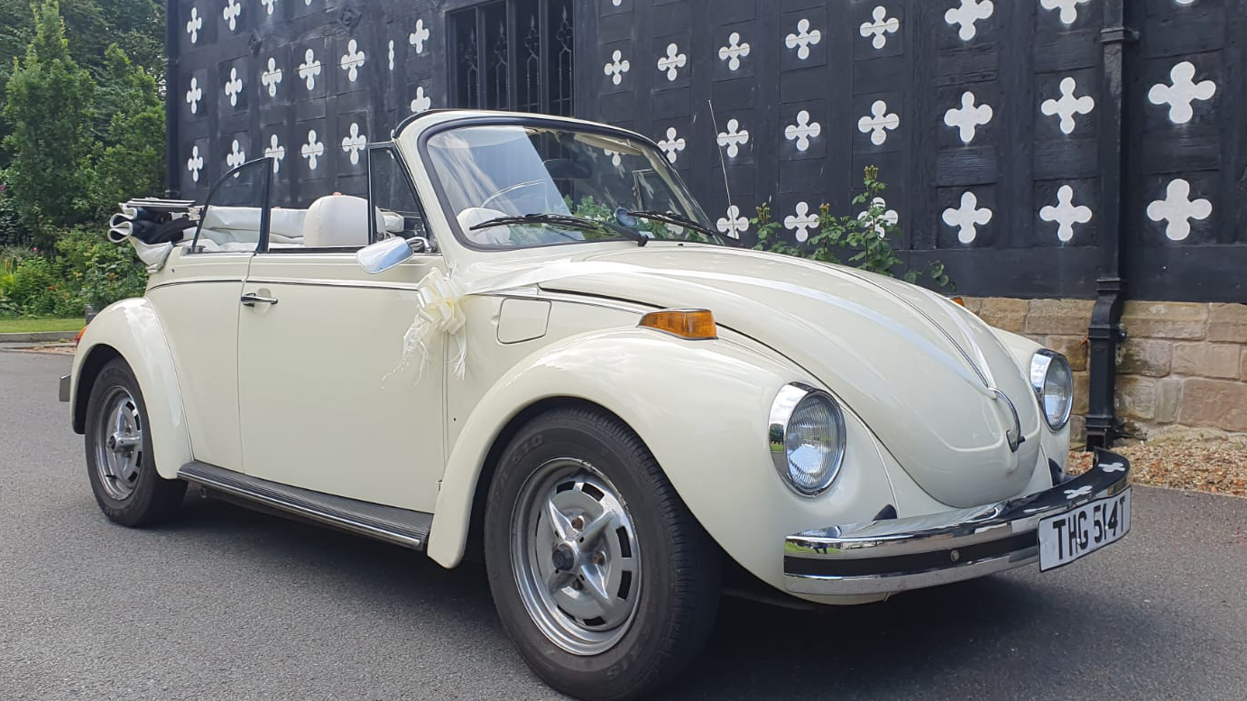 Cream Classic VW Beetle with convertible soft top roof open