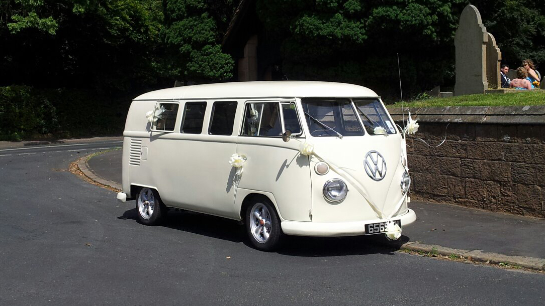 Classic VW campervan in cream in frotn of chruch in Lancashire