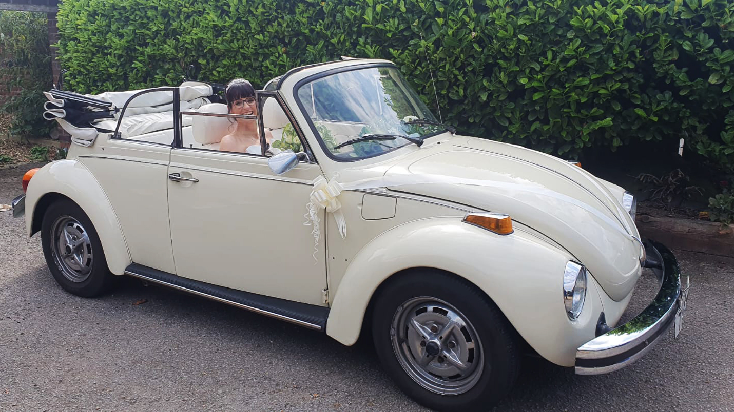 Bride inside a classic Volkswagen beetle with roof open