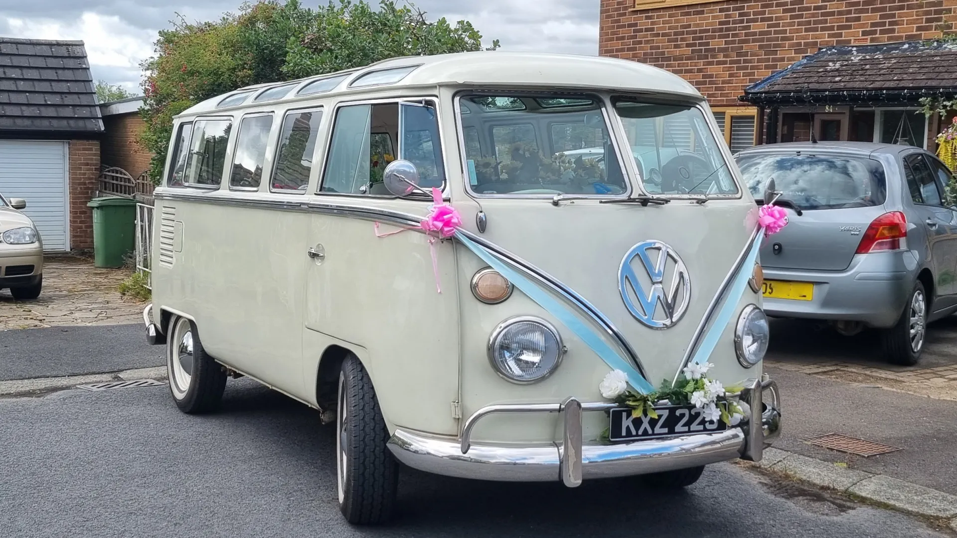 White and Cream Classic VW Campervan splitscreen decorated with wedding ribbons