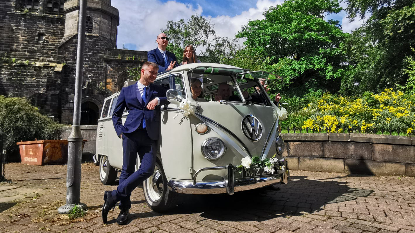 Classic VW campervan parked in street of Southport with Bride and Groom's party posing for photos