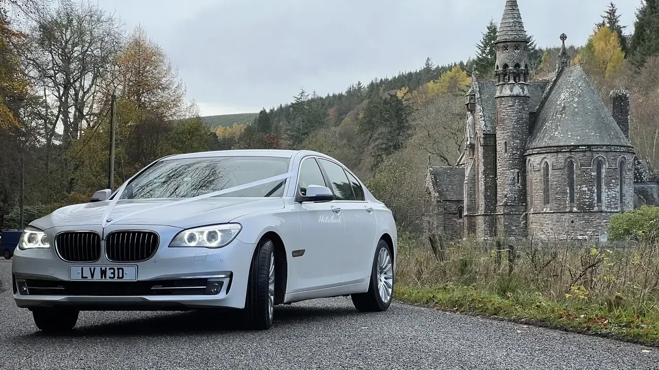 White BMW with ribbons parked in front of Scottish castle