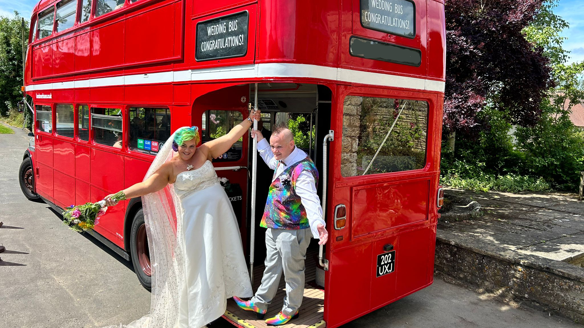 Bride and Groom smiling and standing on the rear open platform