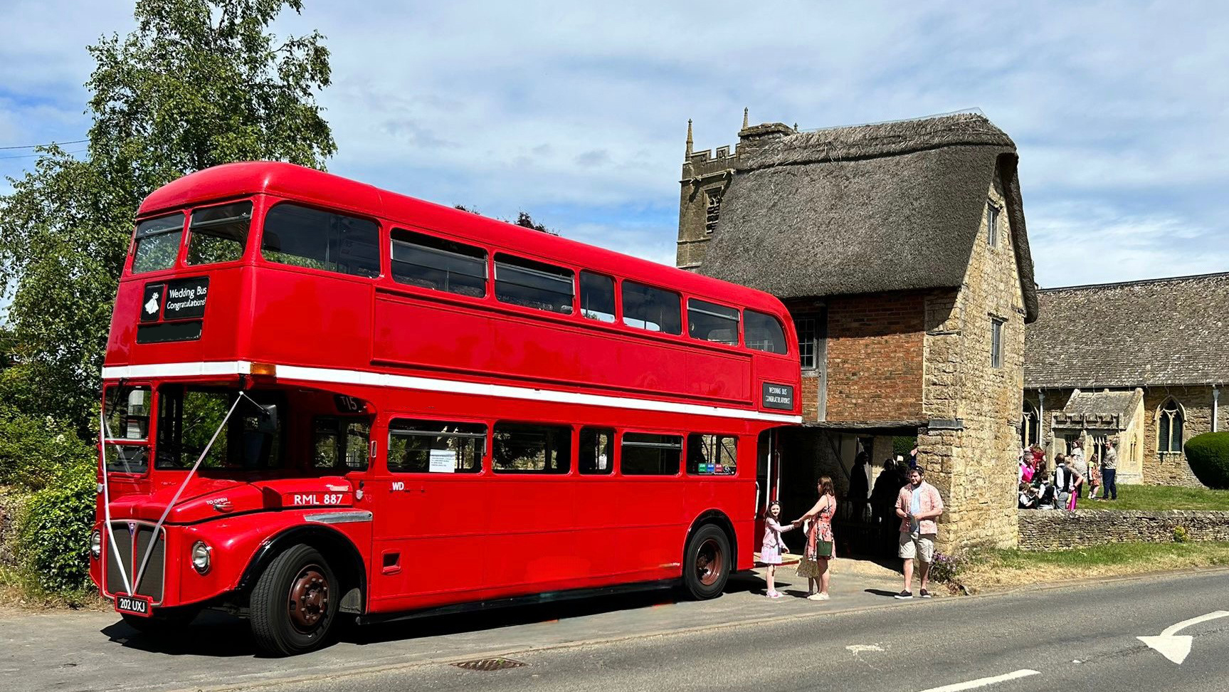 Vintage London Routemaster Bus decorated with Ribbons in front of a church