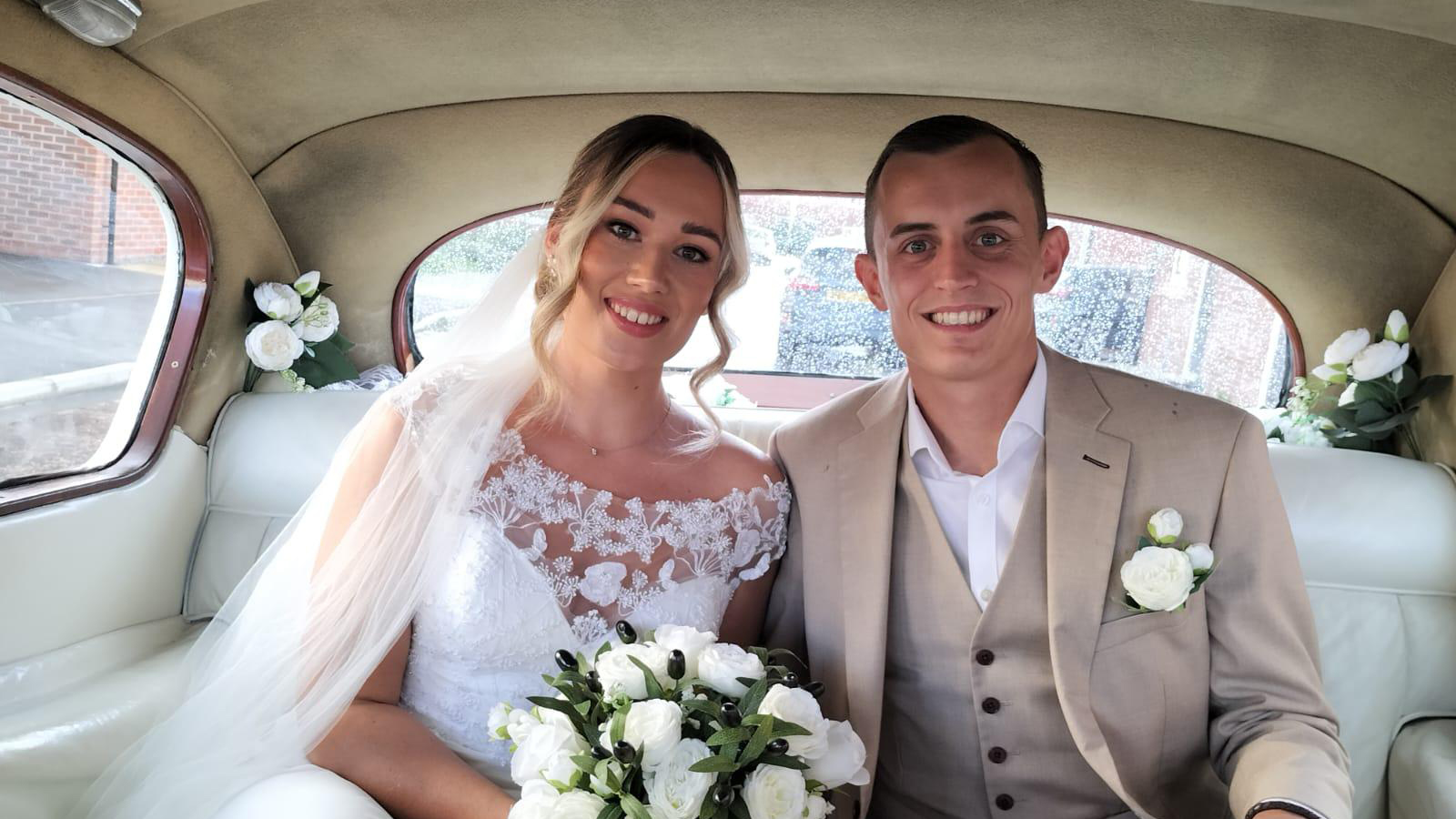 Bride and Groom seating in the rear of a classic Austin Princess Car