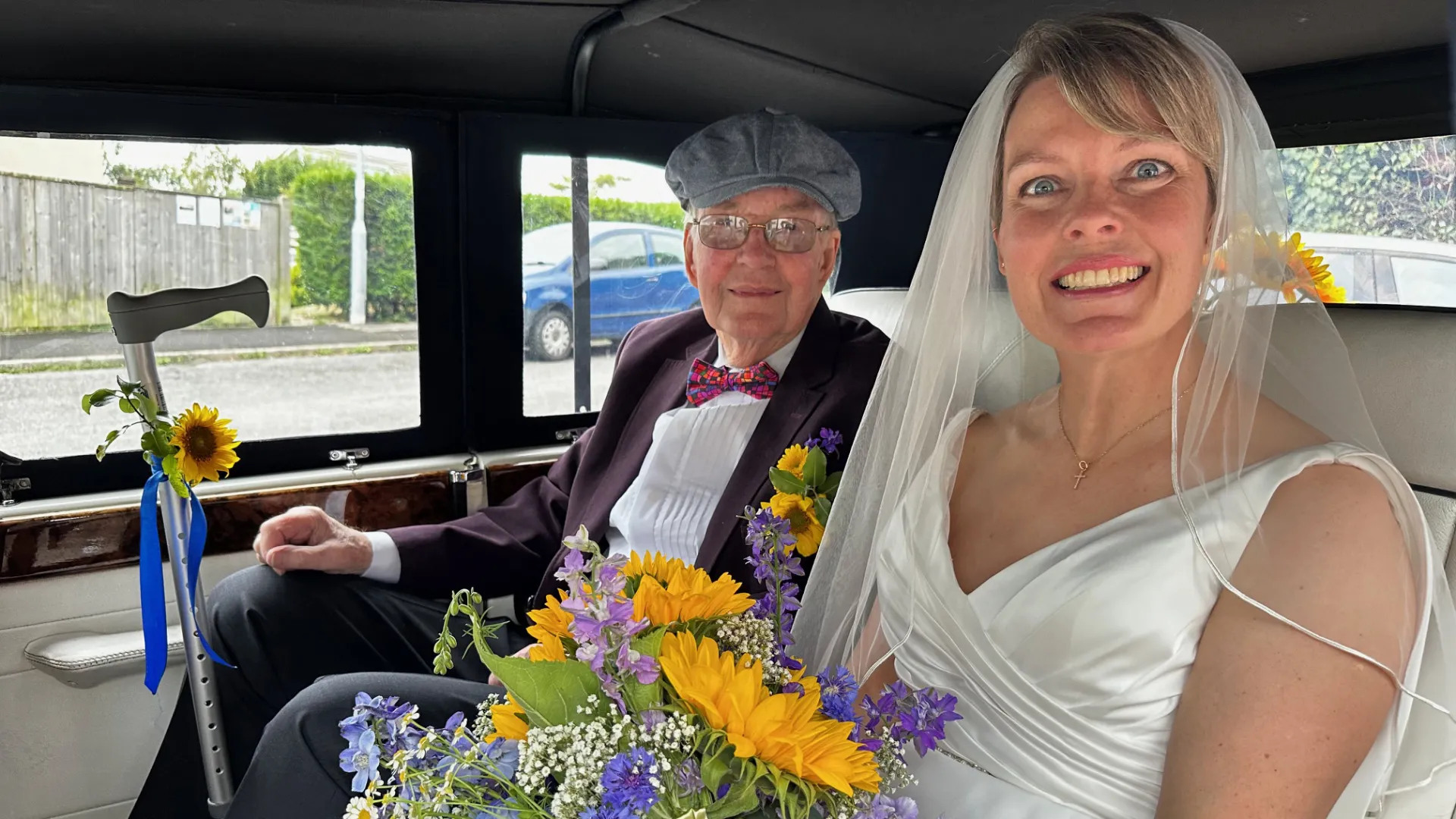 Passengers smiling inside a Beauford convertible