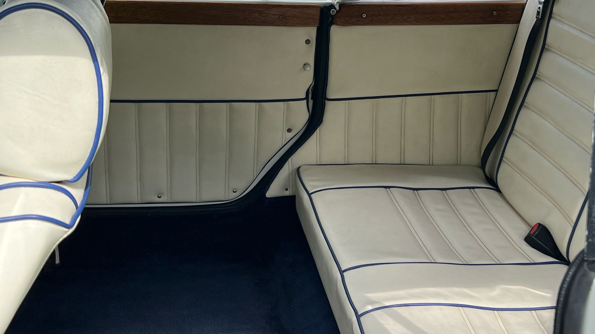 Rear interior seating with Royal blue carpet, cream leather seats and blue pipping