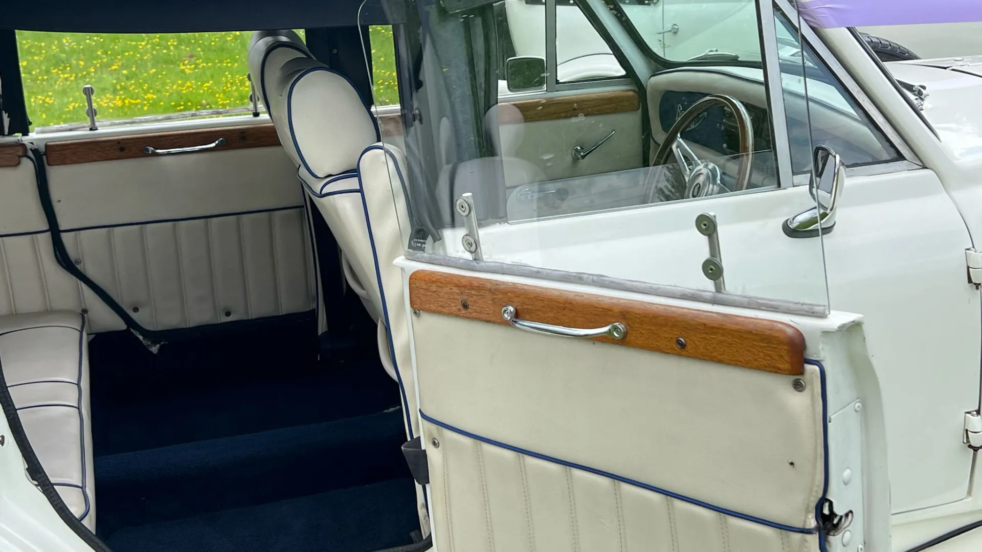 Rear interior photo with royal blue carpet and cream leather seats