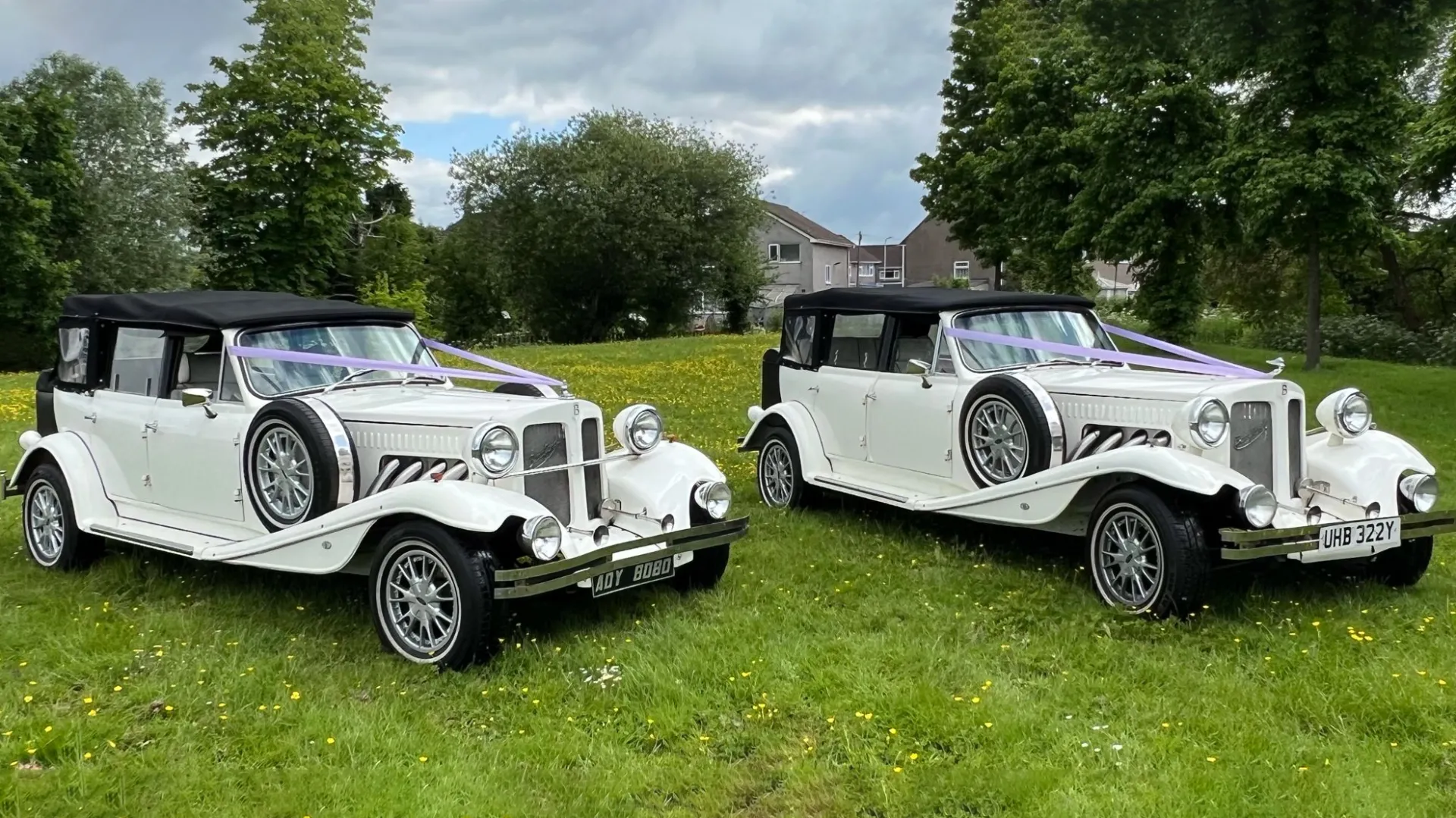 Two identical 1930s vintage style beauford in Ivory with spare wheels mounted on side, black soft top roof