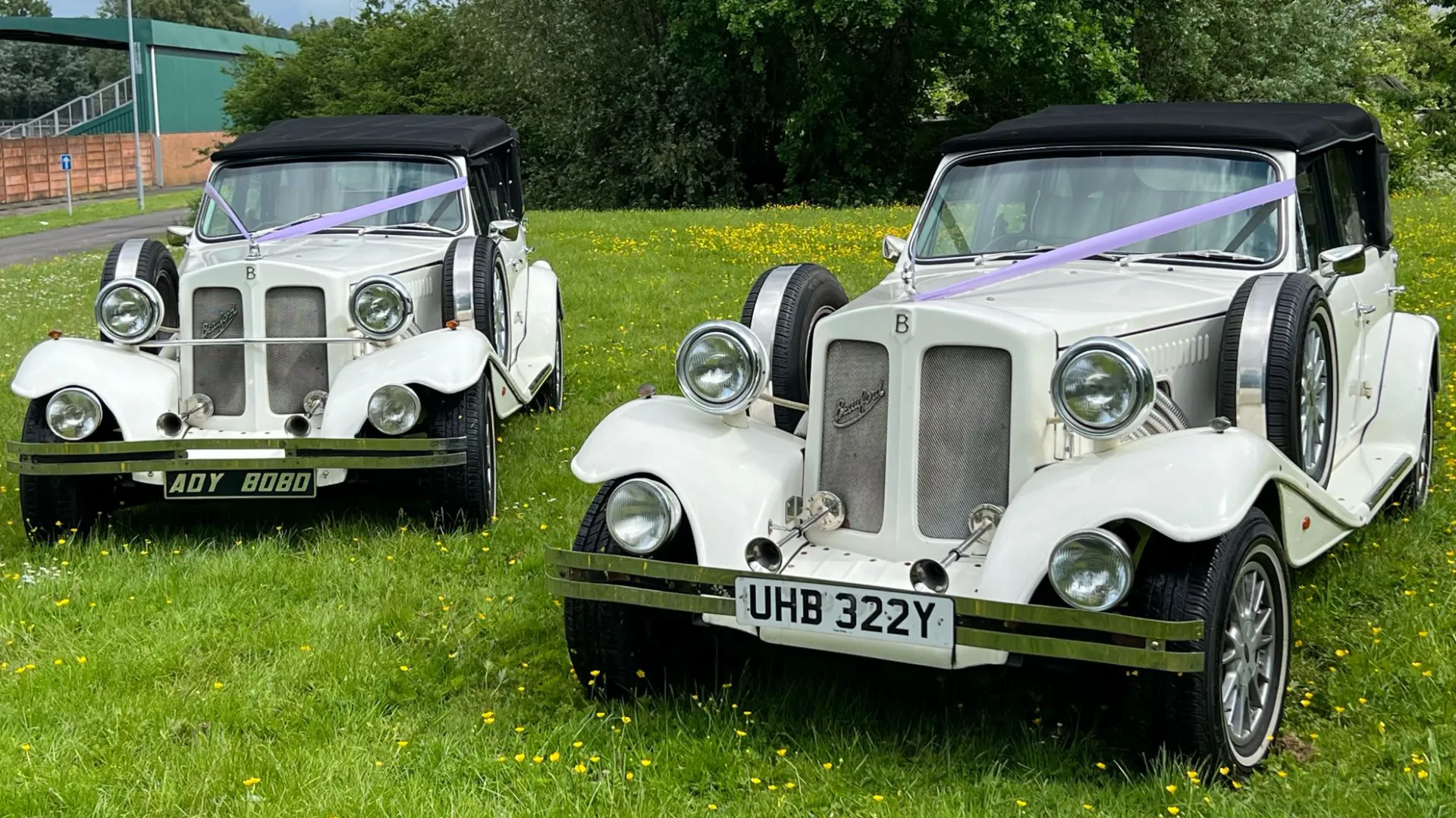 Front view of two identical Ivory Beauford parked side-by-side with their Black soft top roof closed