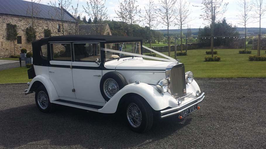 Side view of white vintage style regent with black roof and spoke spare wheel mounted on the side of the vehicle.