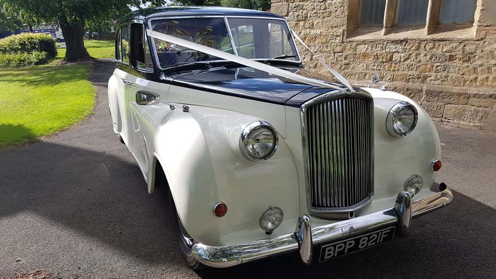 Front view of Austin Princess Limousine in Ivory with Black Bonnet and decorated with Ivory ribbons