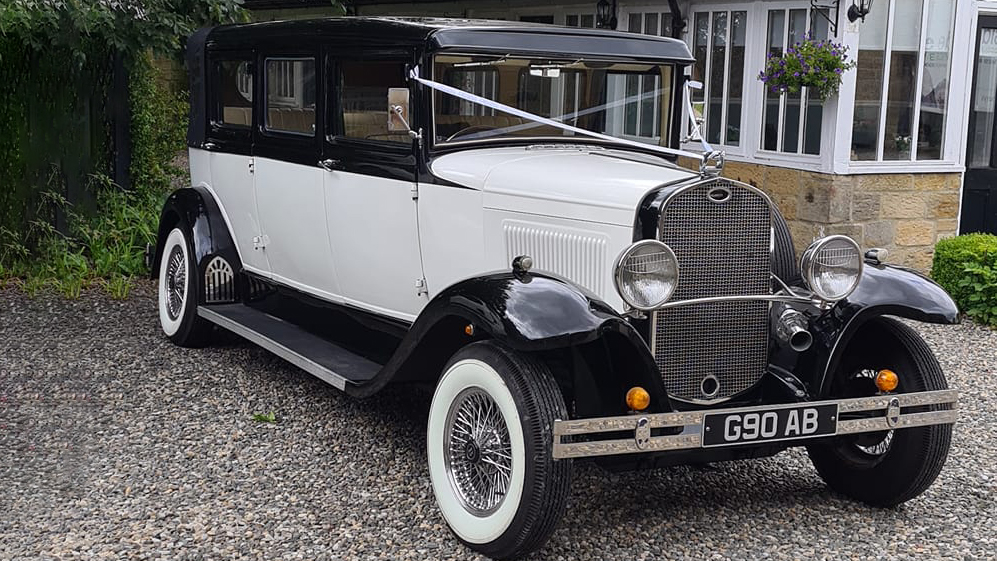 Bramwith limousine wedding car with black wheel arched and roof and ivory on the side and bonnet.