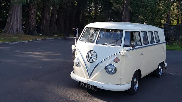 Classic VW Campervan in White and Ivory decorated with white ribbons and bows parked on a drive