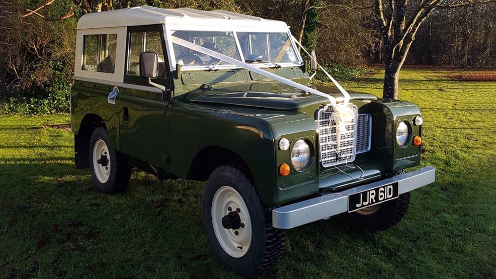 Classic Landrover series 2 in Green with White canvas roof decorated with White ribbons accross its bonnet